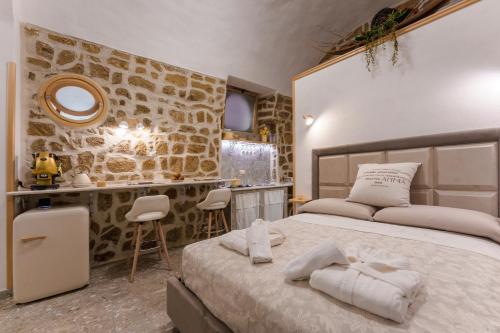 a bedroom with a large bed and a stone wall at Anima Suite - Sauna - Jacuzzi e Cucina in Procida