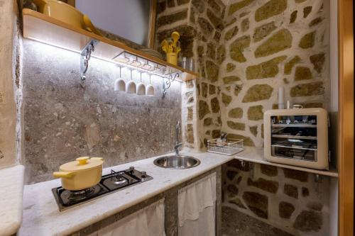 a small kitchen with a sink and a stove at Anima Suite - Sauna - Jacuzzi e Cucina in Procida