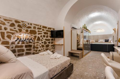 a hotel room with a bed and a bathroom at Anima Suite - Sauna - Jacuzzi e Cucina in Procida