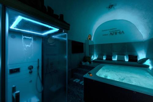 a bathroom with a tub with a blue lighting at Anima Suite - Sauna - Jacuzzi e Cucina in Procida
