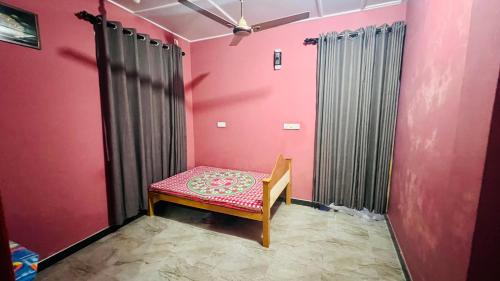 a chair in a room with a pink wall at Ramya’s Villa in Trincomalee