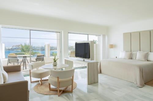 a white hotel room with a bed and a television at Paradisus by Meliá Salinas Lanzarote - All Inclusive - Adults Only in Costa Teguise