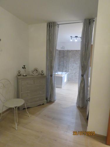 a room with a dresser and a bathroom with a tub at l'altore di savaghju in Vivario