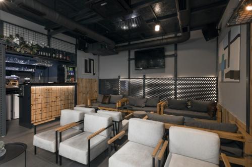 a room with a bunch of chairs and a bar at 9 apartments in Jagodina
