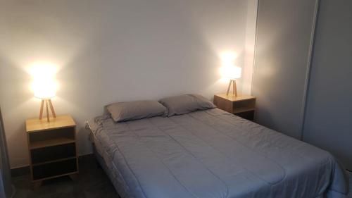 1 dormitorio con 2 lámparas a los lados de una cama en Montiel 364 en Buenos Aires