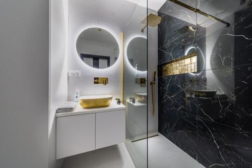 een badkamer met een wastafel en een spiegel bij ResiNest Apartamenty Jurowiecka J11 in Białystok
