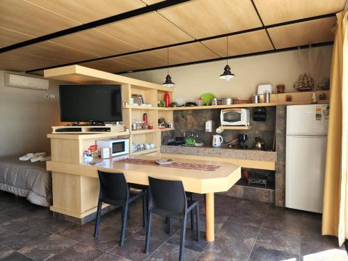 uma cozinha com uma mesa e cadeiras e um frigorífico em APART CLUB San Pedro Río Naturaleza y Relax em San Pedro