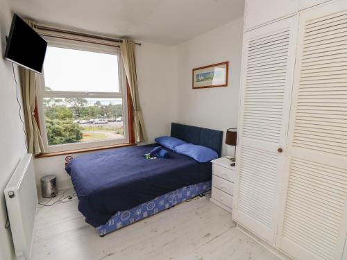 a bedroom with a blue bed and a window at Seaview Central in Southsea