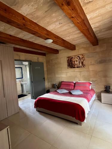 a bedroom with a large bed with red pillows at The Cottage in Luqa