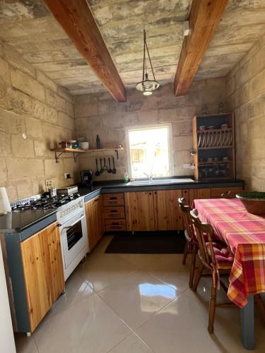 a kitchen with a table and a stove top oven at The Cottage in Luqa