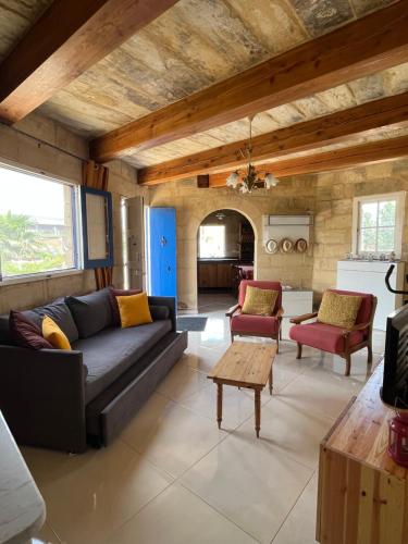a living room with a couch and a table at The Cottage in Luqa