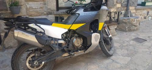 a motorcycle parked in front of a stone building at HOTEL FAMILIAR MAXIMINA in Sallent de Gállego