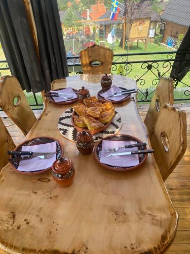 a wooden table with plates of food on it at Vila Deniri in Zlatibor
