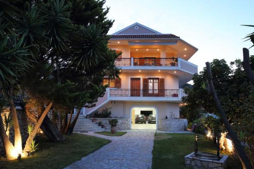 a large white house with a balcony and trees at VILLA CORINA in Apolpaina