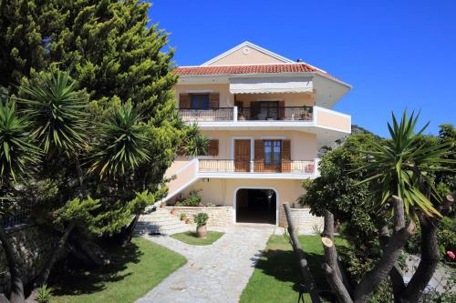 a house with palm trees in front of it at VILLA CORINA in Apolpaina