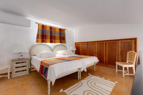 1 dormitorio con 1 cama grande y 1 silla en SOLAR DO MONTE 4, en Albufeira