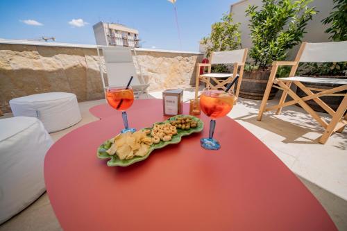 two glasses of wine and a plate of food on a table at Palazzo Fontana B&B e SPA in Gravina in Puglia