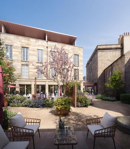 a building with a courtyard with chairs and a table at Bailiffgate Hotel in Alnwick