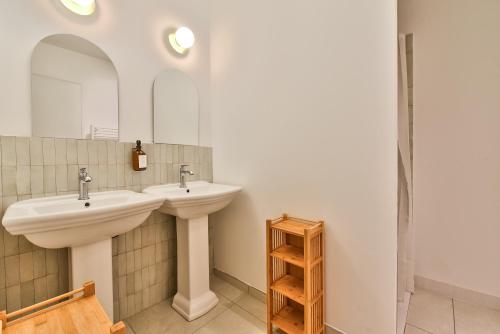 un bagno con due lavandini e uno specchio di NOCNOC - Le Terrazzo - Petite piscine et jardin en ville a Montpellier