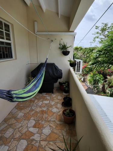 a hammock hanging on the side of a house at Brighton View in Bridgetown