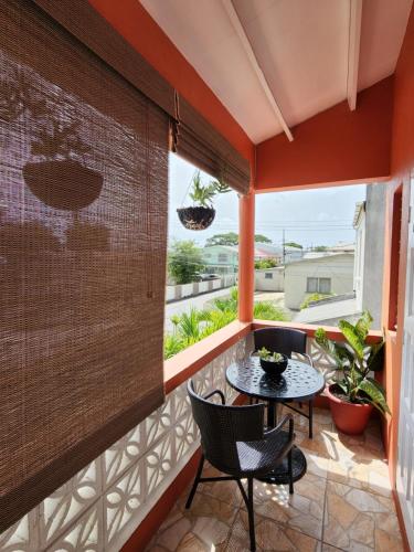 a room with a balcony with a table and chairs at Brighton View in Bridgetown