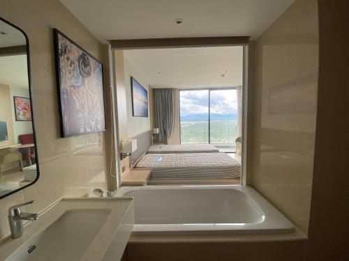 a bathroom with a bath tub and a large mirror at Home Seview at Cam ranh Nha Trang Aparment in Cam Ranh