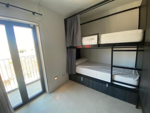 una camera con letto a castello e finestra di We Street Hostel - El Arenal-Albergue juvenil a El Arenal