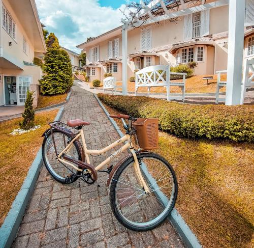 a bike parked on a brick path in front of a house at Pousada Nacional Inn Campos do Jordão in Campos do Jordão