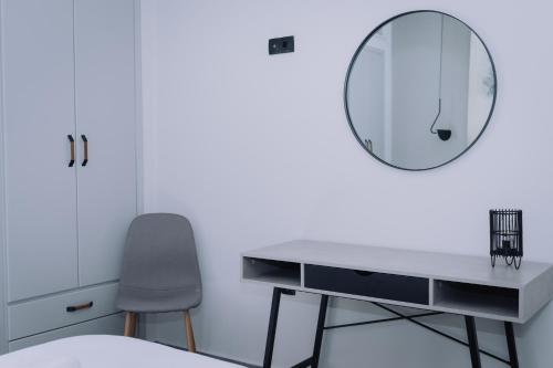 a desk with a mirror and a chair in a room at Vallia Suites-Yellow Luxury Suite A1 in Nafpaktos