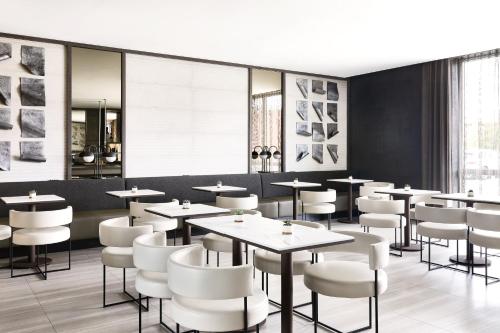 マイアミにあるAC Hotel by Marriott Miami Airport West/Doralのダイニングルーム(テーブル、白い椅子付)