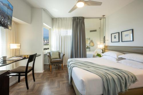 a hotel room with a large bed and a desk at Maxim Design Hotel 3 Star Superior in Tel Aviv