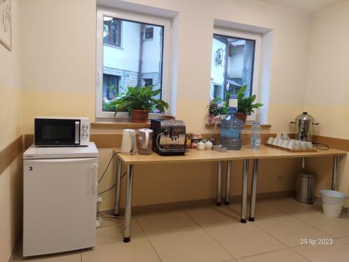 a kitchen with a table with a microwave on it at Karmelitański Dom Gościnny in Zawoja