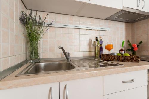 a kitchen sink with a vase of flowers on it at Apartments Dubrovnik Lapad in Dubrovnik