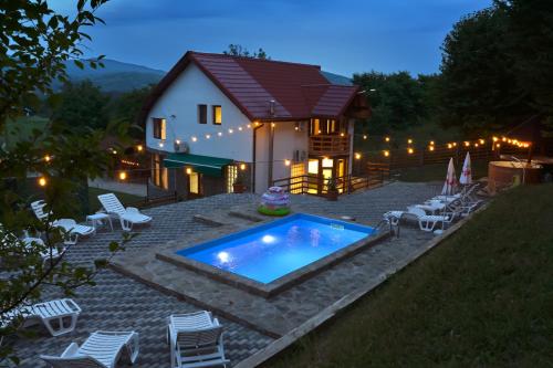 a house with a swimming pool in front of it at Casa Nikolia in Măgura