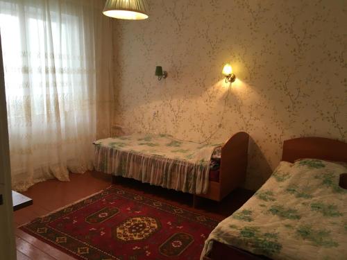 een kleine kamer met een bed en een tapijt bij Квартира в городке Бостери in Bosteri