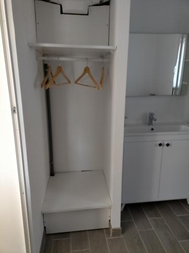 a bathroom with white cabinets and a sink and a bench at Beau studio indépendant à15mn de la plage, proche de toute commodité in Béziers
