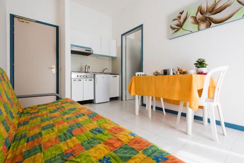 una camera con cucina, tavolo e sedie di Aparthotel Pineda a Bibione