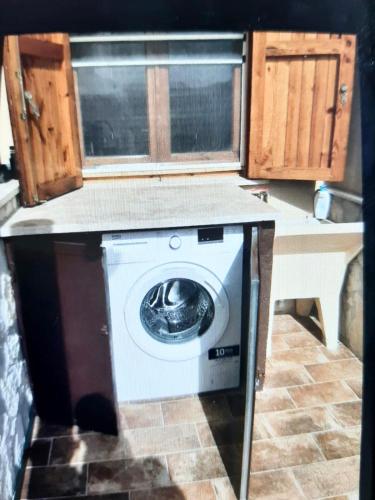 a washer and dryer in a kitchen with wooden cabinets at Ma. De House Lago del Turano in Valle Verde