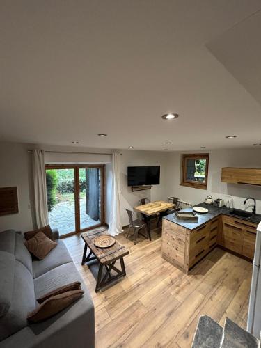 une cuisine et un salon avec un canapé et une table dans l'établissement Logement avec jardin et vue panoramique MontBlanc, aux Houches