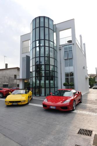 two luxury cars parked in front of a building at Hotel In - Lounge Room in Cazzago di Pianiga