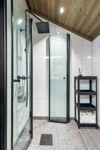 a glass shower door in a bathroom with a shelf at Hodlekvevegen 307 in Sogndal