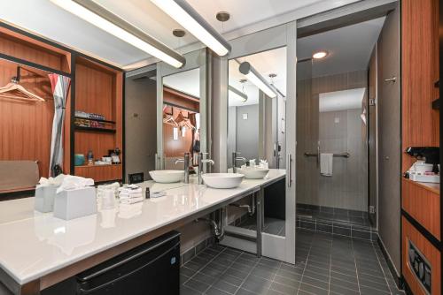 a bathroom with two sinks and two mirrors at Aloft Charlotte City Center in Charlotte