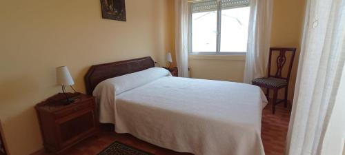 - une chambre avec un lit blanc et une fenêtre dans l'établissement EnFOZ El Azul del Mar, à Foz