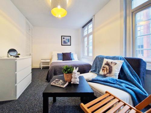 a bedroom with a bed and a couch and a table at Private room near Tower of London in London