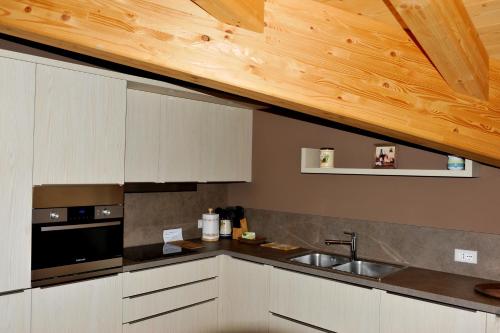 a kitchen with a sink and a wooden ceiling at Casa Reit in Bormio