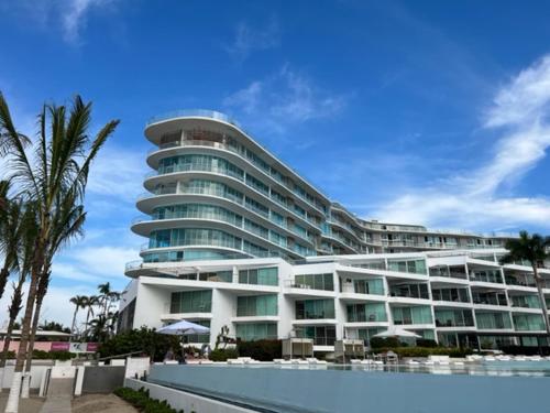 a large building with a pool in front of it at De las mejores vistas del Condominio in Nuevo Vallarta 
