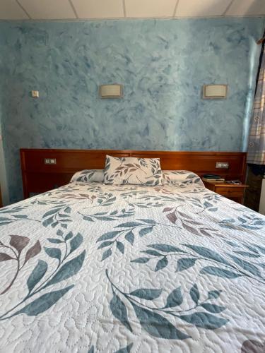 una camera con un grande letto con una parete blu di Alojamiento La Milana a La Robla