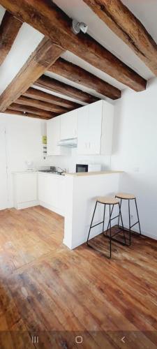 une cuisine avec des armoires blanches et un plancher en bois dans l'établissement Studio Bord de Marne, à La Ferté-sous-Jouarre