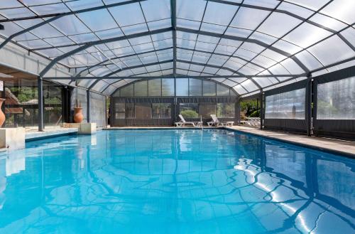 an indoor swimming pool with a glass roof and a swimming poolvisor at Wyndham Garden Luján in Luján