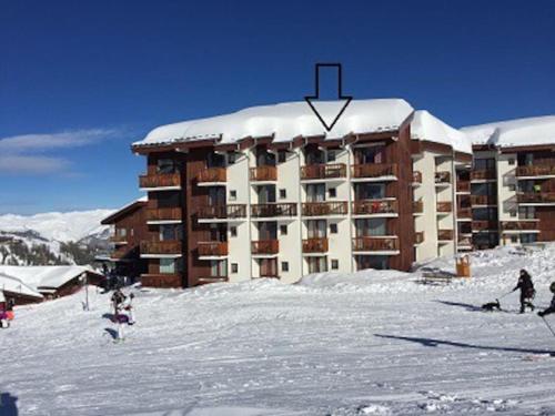 um grande edifício com neve em cima em Duplex plein sud_skis aux pieds_Plagne villages em La Plagne Tarentaise